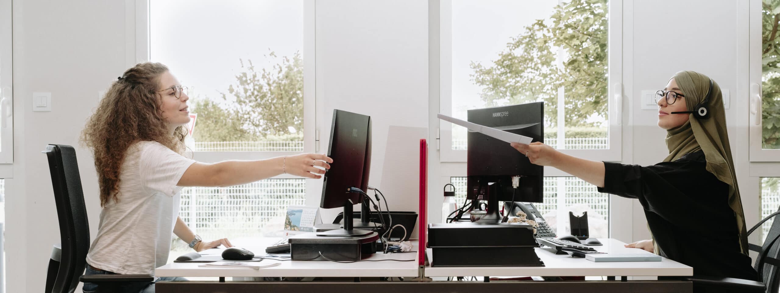 image de deux collaboratrices Dimotrans assises a leurs bureaux , l'une en face de l'autre